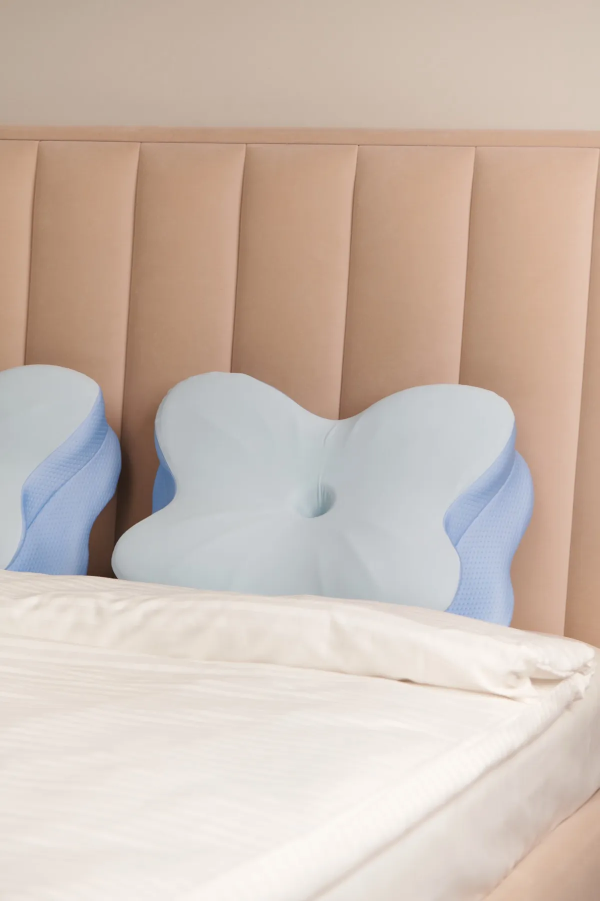 Ergonomic memory foam pillow placed on a bed showing the butterfly-shaped contoured design